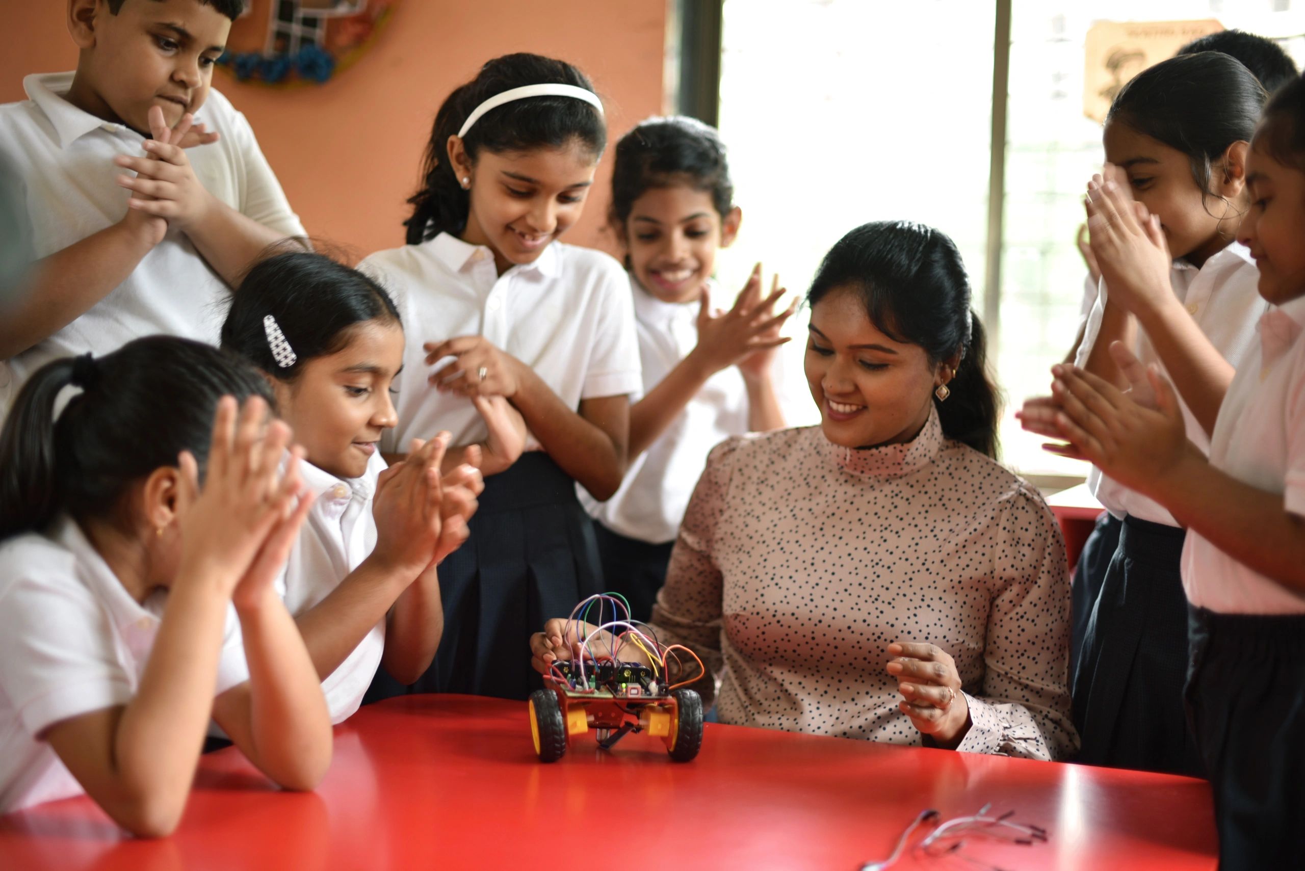 Teacher and students celebrating a successful robotics activity