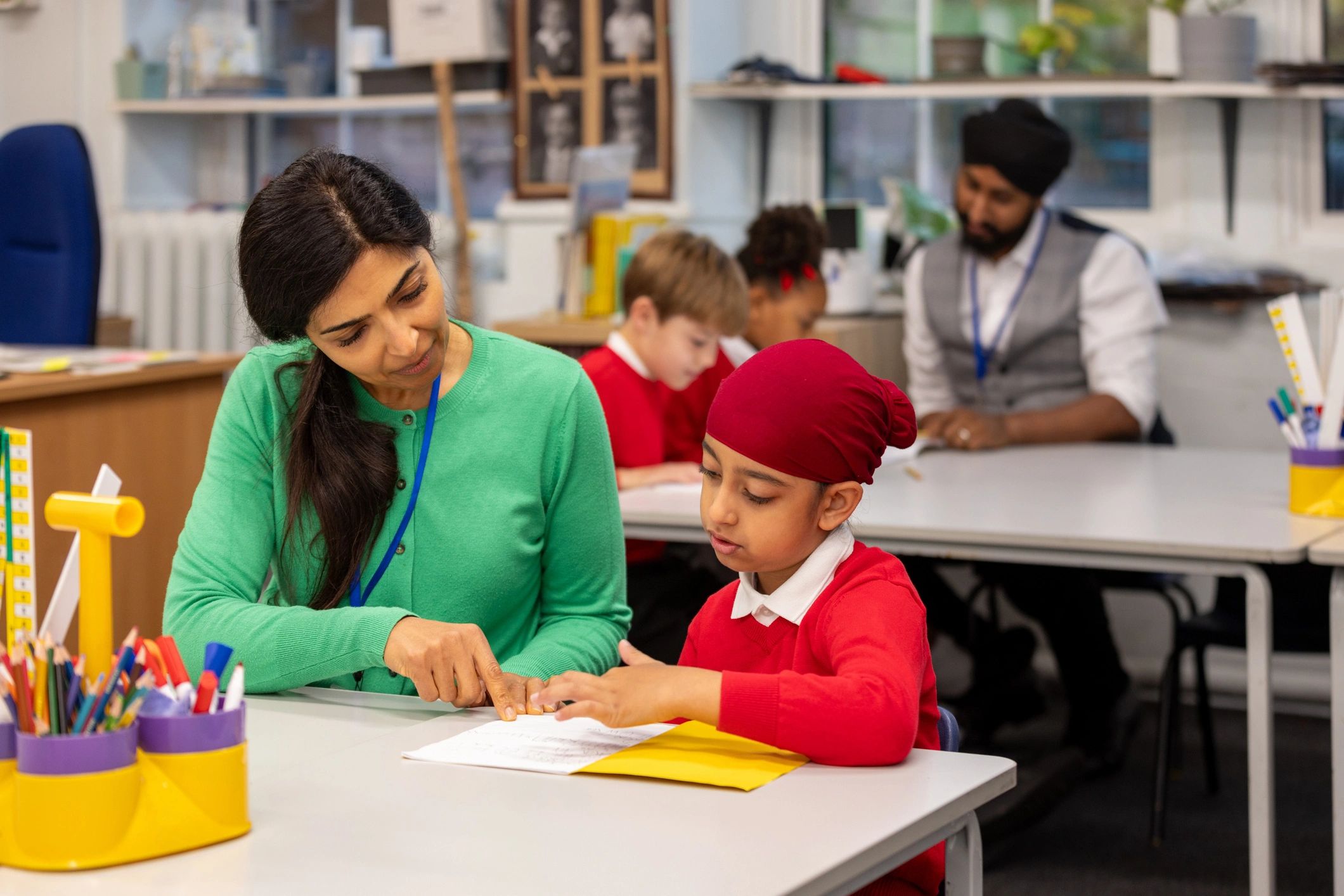 Teacher interacting with young students during a hands-on classroom activity